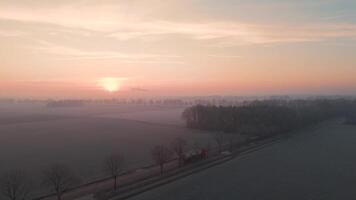 Aerial view of a field with a train passing by at sunrise video