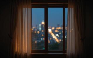A window with curtains and a city view at night photo