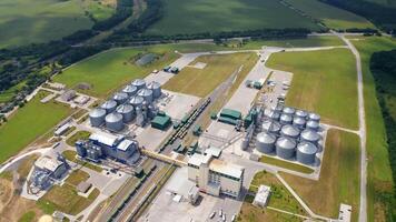 Modern agrocomplex on field. Grain elevators for storing crop. Large industrial territory with storage tanks. Freight trains on rails. Aerial view. video