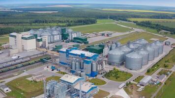 Modern industry surrounded by nature. Grain elevators on large agriculture factory on field. Grain-drying complex in rural land. Aerial view. video