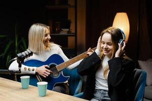 Musicians recording a song with acoustic guitar and microphone in a studio photo