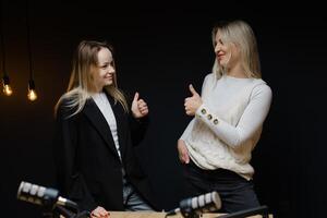 Two podcasters pointing and laughing during a recording session. photo