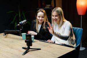 Two Content Creators Waving at Camera During Live Podcast Recording. photo
