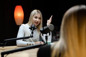 Two female podcasters recording a new episode in a professional studio. photo