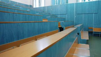 Empty lecture hall. Auditorium with wooden desks and chairs at educational center. Conference hall without students in the university. video