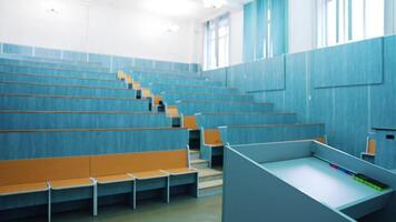 Modern auditorium with wooden desks without people. Large meeting hall with empty desks. Nobody in lecture hall in the university during quarantine. video
