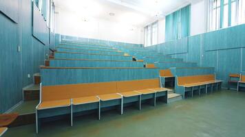 Comfortable classroom without students. Empty auditorium with wooden desks in blue color. Light lecture hall in the University. video