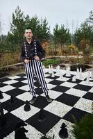 A Whimsical Gardener Playing on a Giant Colorful Chessboard with Unique Artistic Concepts photo