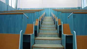 Empty auditorium. Stairs between two rows of desks in conference hall. Beautiful class for studying without students. Classroom in the university with wooden desks. video