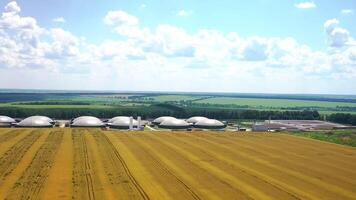 Modern bio farm surrounded by green nature. Innovative agriculture reservoirs for bio gas production on field in summer. Aerial view. video