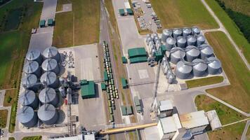 Agricultural silos on field. Grain elevators for storage and drying of cereals. Modern grain-drying complex. Orbital view from above. video