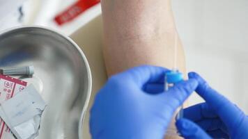 sangre muestreo en el laboratorio. laboratorio trabajador médico toma un sangre muestra para análisis. procedimiento de tomando sangre en clínica. de cerca. video