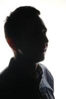 Silhouette of a Thoughtful Individual Pondering Deeply Against a Bright Backlight Background photo