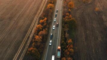 An aerial view of cars driving along a highway during an autumn sunset. video