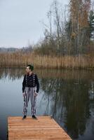 A Mysterious Character Standing upon a Dock Surrounded by Tranquil and Serene Waters photo
