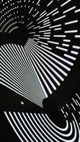 An intriguing low-angle shot captures a dynamic abstract pattern formed by bright light filtering through a perforated surface onto a dark, curved tunnel. The interplay of luminous dots video