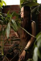 A Contemplative Woman is Surrounded by Lush Greenery in a Beautiful, Modern Space photo