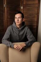 A Thoughtful Youth in a Stylish Modern Setting Ideal for Reflection and Creativity photo