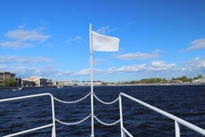 A Serene River Journey unfolds under Cloudy Skies, highlighted by a White Flag fluttering gently photo