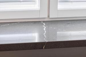 This Elegant Gray Countertop Features Striking Veins and Receives Ample Natural Light photo