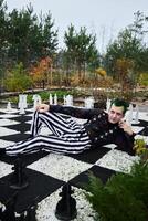 A Fashionable Chessboard Pose in Stylish Striped Attire Set Against a Beautiful Background photo