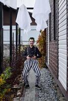 A Playful Clown Wearing Colorful and Striped Pants Cheerfully Poses by the Charming Pathway photo