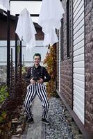 A whimsical clown adorned with ghost decorations is set in a vibrant outdoor environment photo