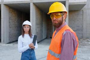 Construction workers inspecting building site progress, architect and foreman discussing project. photo