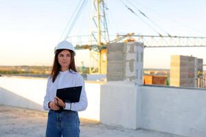 Female engineer showing a document to a construction worker on a rooftop. photo
