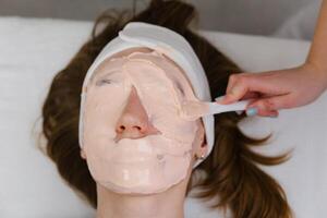 Applying a Rejuvenating Facial Mask at Spa photo