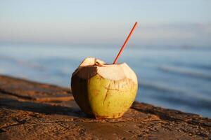 Coconut drink on the beach with a straw photo