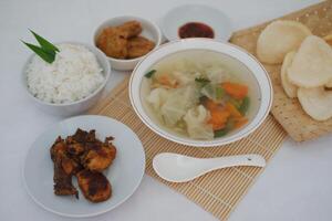 A Delicious Indonesian Meal with Rice, Chicken, Soup and Crackers photo