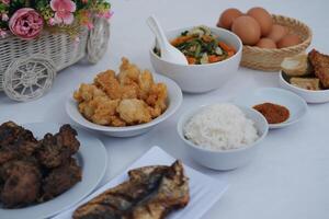 A Complete Indonesian Meal Rice, Fried Chicken, Vegetables and Eggs photo