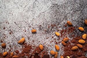 almonds, dark chocolate, cocoa powder on a gray neutral concrete background photo