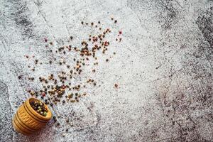 a mixture of peppers, spices sprinkled on a gray table photo