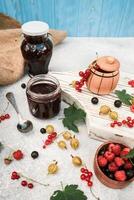 assortment of jam, seasonal berries of black, red currant, gooseberry and raspberry photo