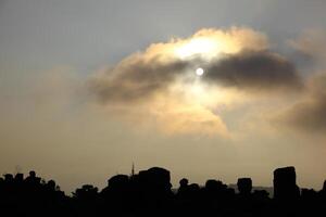Dark Rocks under the sun behind a cloud photo