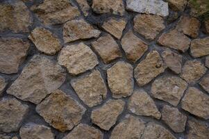 Close-up of a natural stone wall in Cyprus, showing rustic texture and warm colors, perfect as a background or design element. photo