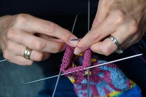 Detailed knitting of a sock with a complex pattern. Artistic handcraft, close-up of the work in progress. photo