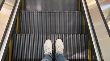 Top View of Feet in Sneakers Taking Escalator Down to Lower Floor video