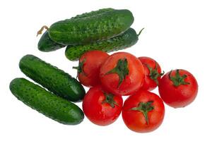 Tomatoes and cucumbers isolate on white. Vegetables red tomatoes and green cucumbers. photo
