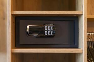 A sleek safe is mounted within a wooden shelf, featuring a digital keypad. This setup highlights the importance of secure storage in a modern space photo