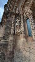 Temple of the Sacred Heart. Tibidabo. Ornate stone sculpture of a figure embedded in a textured wall, showcasing intricate details and architectural beauty in a historical setting photo
