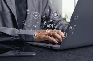 Hands Typing on Laptop with Visual Representation of API Concepts photo