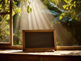 Rustic chalkboard on wooden table with sunrays through green leaves. photo