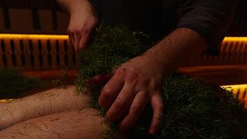 Closeup View Of Hands Of Bath Attendant Putting Fir Branches On Legs, Massage With Essential Oils video
