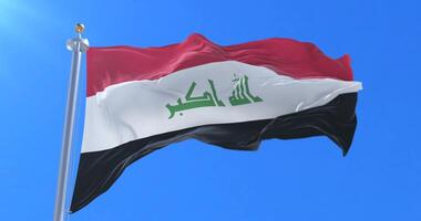 Flag of Iraq waving at wind in slow in blue sky, loop video