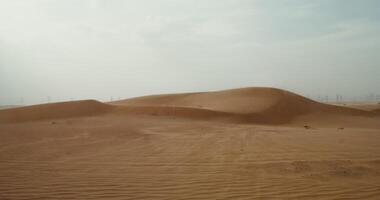 Wind inflates the sands of the desert, forming a beautiful sandy pattern. Desert sand dunes. Power lines in the background. 4k , red komodo photo