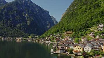 Small Austrian town located on the coast of a picturesque lake at the foot of green mountains. Austria, Hallstatt, drone photo