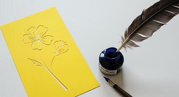 A yellow card with a flower on it next to a pen and ink photo